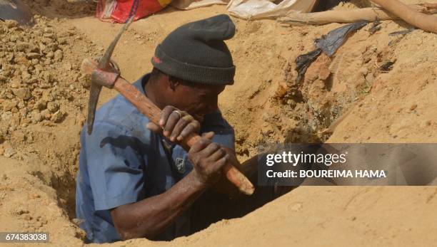 Man digs in a hole as hundreds of people search gold on April 25, 2017 in Kafa-Koira, south of Niamey. Hundreds of people, sometimes whole families,...