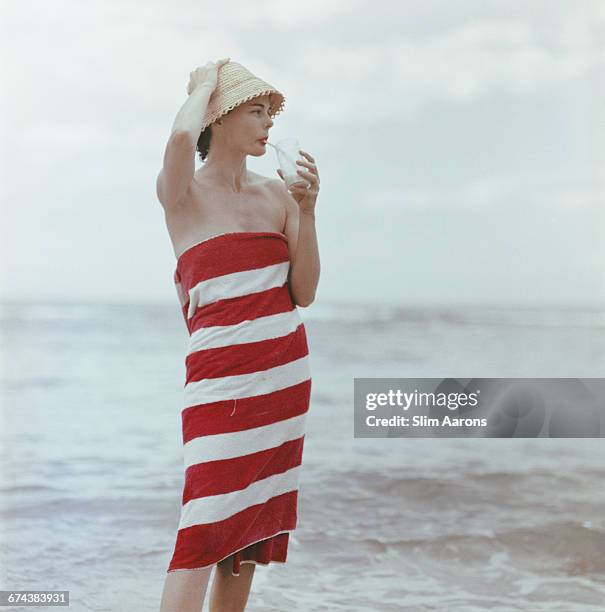 Actress Dee Hartford, wife of film producer Howard Hawks, sips a Pussyfoot - a mixture of Jamaican fruit juices, 1958.