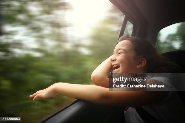 a girl breathing air through the window of a car - freedom of expression stock-fotos und bilder