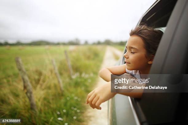 a girl breathing air through the window of a car - kid looking through window stock pictures, royalty-free photos & images