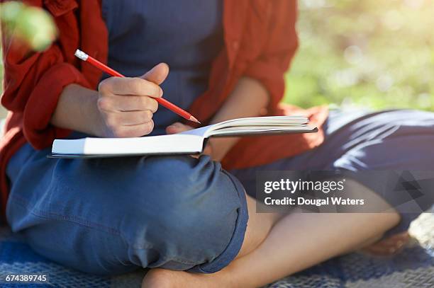 woman writing in note book. - stories of the day stock-fotos und bilder