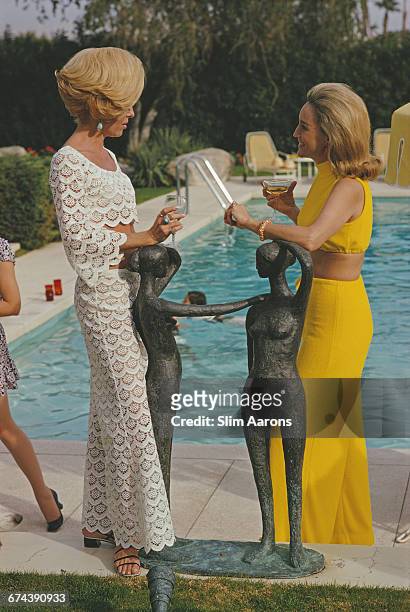 Former fashion model Helen Dzo Dzo talking to Nelda Linsk, wife of art dealer Joseph Linsk, at the Kaufmann Desert House in Palm Springs, California,...