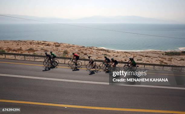 Foreign and Israeli cyclists ride on the road along the Dead Sea in the Israeli-section of the Judaean desert, during the fifth and the last day of...