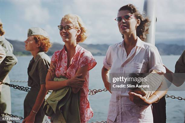 American actress Cynthia Stone and Rita Aarons, wife of photographer Slim Aarons, watch the filming of John Ford's 'Mister Roberts', Hawaii, 1955.