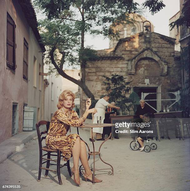 Actress Melina Mercouri enjoys a coffee and a cigarette at a quiet pavement cafe, Plaka, Athens, 1961.