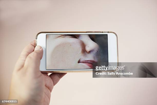 childs face squashed on a smart phone - horizontal stock-fotos und bilder