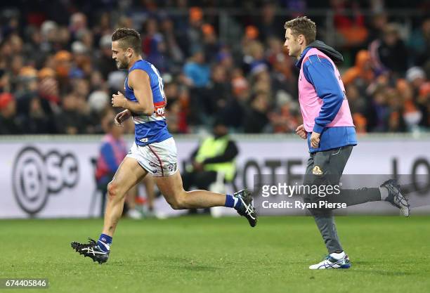 Luke Dahlhaus of the Bulldogs leaves the ground with an arm injury during the round six AFL match between the Greater Western Sydney Giants and the...