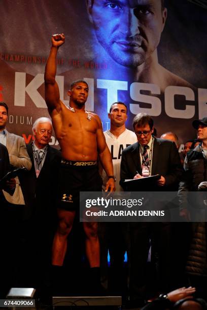 British boxer Anthony Joshua stands on the scales with Ukrainian boxer Wladimir Klitschko beside him during the weigh-in event at Wembley in London...