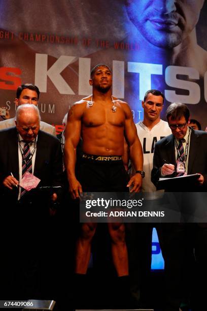 British boxer Anthony Joshua stands on the scales with Ukrainian boxer Wladimir Klitschko beside him during the weigh-in event at Wembley in London...