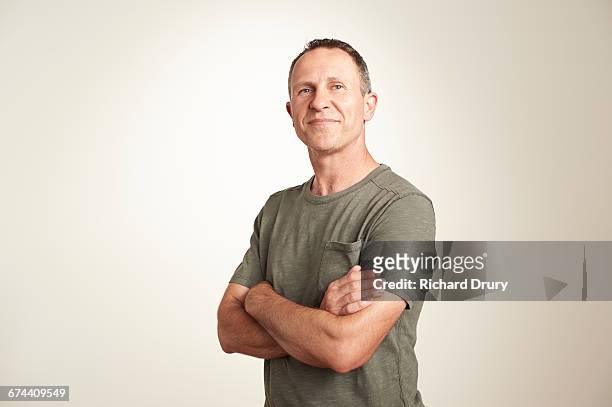 portrait of thoughtful middle-aged man - braços cruzados imagens e fotografias de stock