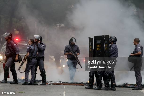 Police officers stand guard as protestors demonstrate at Ipiranga Ave. In Sao Paulo, Brazil on April 28, 2017. A nation-wide general strike has been...