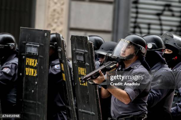 Police officers stand guard as protestors demonstrate at Xavier de Toledo street in Sao Paulo, Brazil on April 28, 2017. A nation-wide general strike...