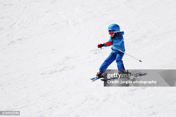 little child skiing down hill - pantaloni da sci foto e immagini stock