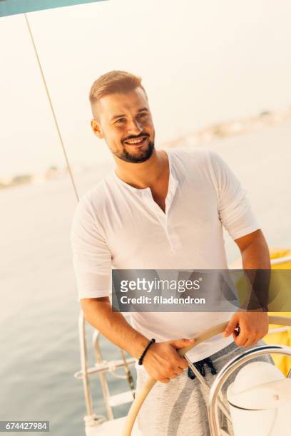 man sailing a yacht - boat steering wheel stock pictures, royalty-free photos & images