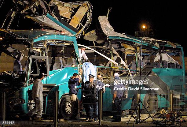 Israeli police inspect the wrangled remains of an Israeli passenger bus after it was blown apart by a Palestinian suicide bomber November 29, 2001...