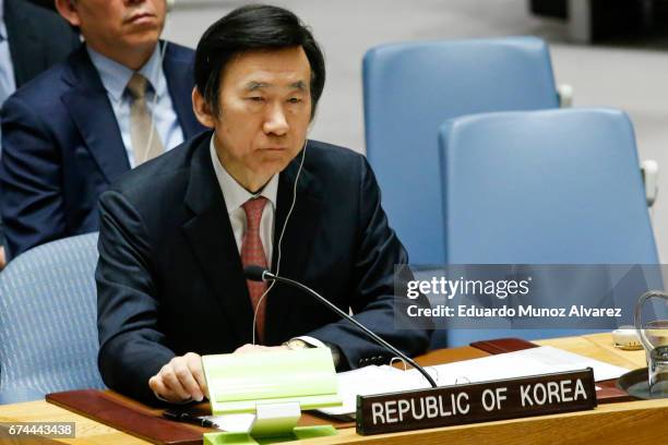 South Korean Foreign Minister Yun Byung Se listens China's Foreign Minister Wang Yi as he speaks to members of the security council during a meeting...