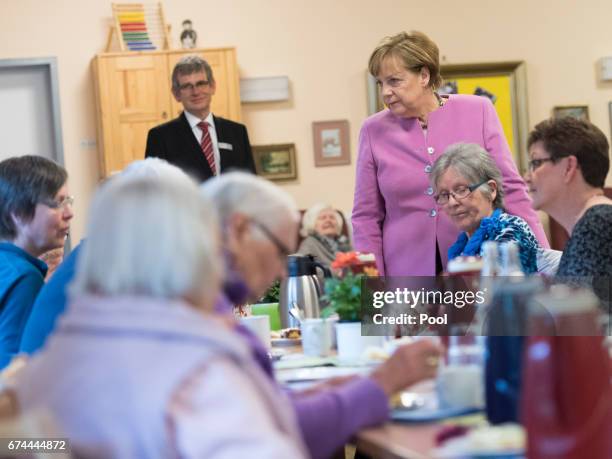 German Chancellor Angela Merkel chats with residents during a visit to the Gustav-Schatz-Hof senior care facility on April 28, 2017 in Kiel, Germany....