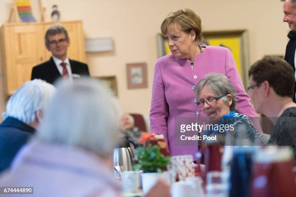 German Chancellor Angela Merkel chats with residents during a visit to the Gustav-Schatz-Hof senior care facility on April 28, 2017 in Kiel, Germany....