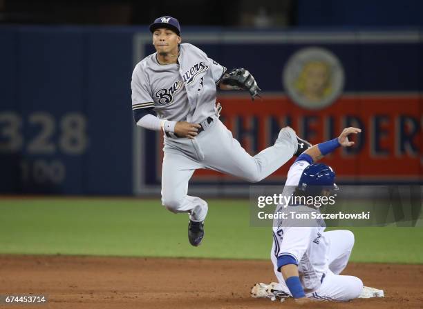 Orlando Arcia of the Milwaukee Brewers turns a double play in the ninth inning to end the game during MLB game action as Jarrod Saltalamacchia of the...