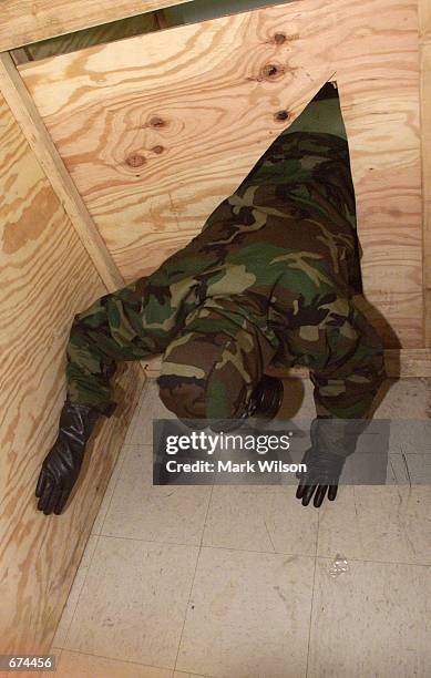 With the eye glass on his gas mask taped over, a US Marine enters a small enclosure and to blindly find his way to the end during a training exercise...