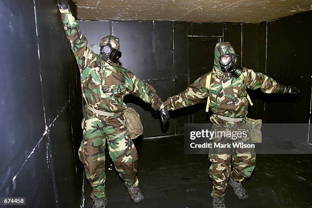 Two US Marines wearing gas masks navigate a dark building during a training exercise on chemical and biological response November 29, 2001 in Indian...