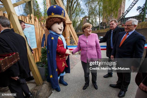 German Chancellor and Chairwoman of the German Christian Democrats Angela Merkel greets the 'Little Zar'-mascot as she opens a roller coaster for...