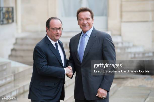 Actor and former governor of California Arnold Schwarzenegger is welcomed by French president Francois Hollande prior to a meeting at the Elysee...