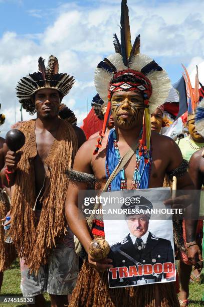 Indigenous people display a poster depicting President Michel Temer as WW2 Nazi dictator Adolf Hitler as they march at the Esplanade of the...