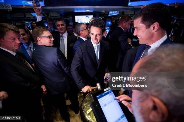 Ernie Garcia, founder and chief executive officer of Carvana Co., center, rings a ceremonial bell during the company's initial public offering on the...