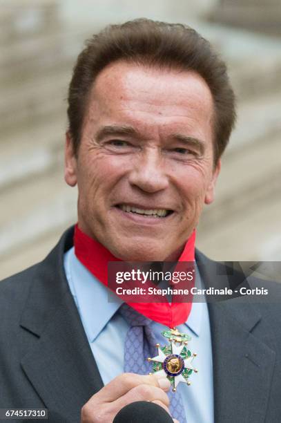 Actor and former governor of California Arnold Schwarzenegger poses after he was awarded France's highest national order the 'Chevalier de la Legion...