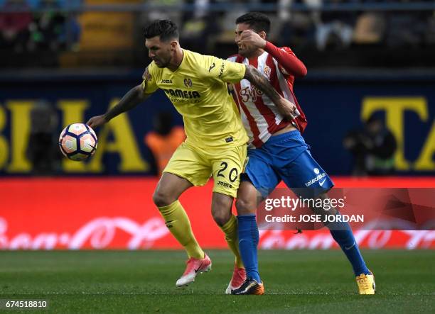 Villarreal's Italian midfielder Roberto Soriano vies with Sporting Gijon's forward Carlos Carmona during the Spanish league football match Villarreal...
