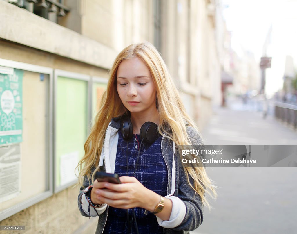 A teenage girl looking at her cell phone