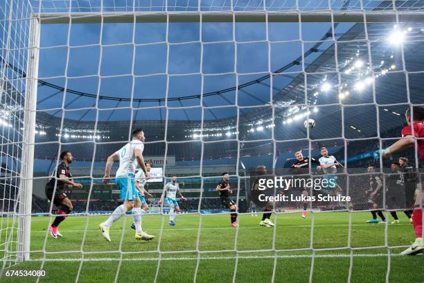 Benedikt Hoewedes of Schalke scores his teams second goal against Julian Brandt of Leverkusen during the Bundesliga match between Bayer 04 Leverkusen...