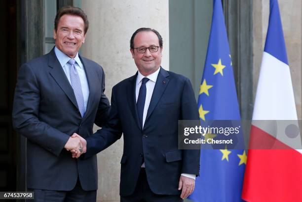 French President Francois Hollande welcomes actor and former US Governor of California Arnold Schwarzenegger as he arrives for a meeting at the...