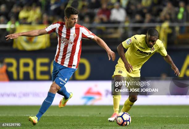 Sporting Gijon's midfielder Mikel Vesga vies with Villarreal's Congolese forward Cedric Bakambu during the Spanish league football match Villarreal...