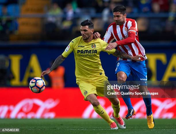 Roberto Soriano of Villarreal competes for the ball with Carlos Castro of Real Sporting de Gijon during the La Liga match between Villarreal CF and...