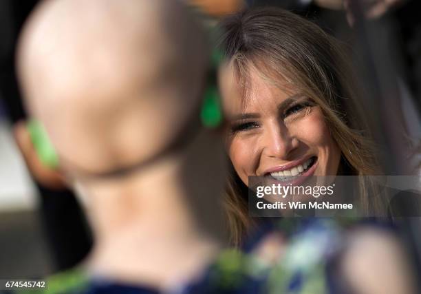 First lady Melania Trump greets a young patient at the Children's National Health System April 28, 2017 in Washington, DC. Trump spoke a the opening...