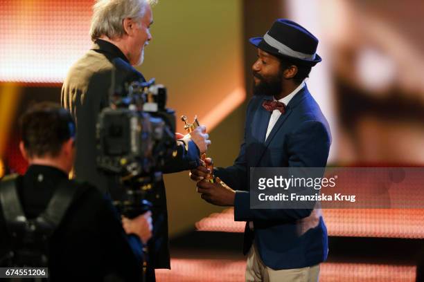Reinhold Vorschneider receives the Award for Best Cinematography from actor Eric Kabongo at the Lola - German Film Award show at Messe Berlin on...