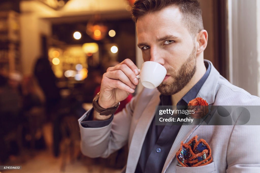 Uomo che beve un espresso al bar