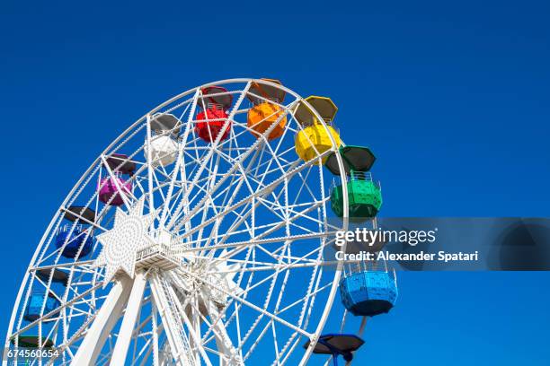 colorful ferris wheel agains clear blue sky - big wheel stock pictures, royalty-free photos & images