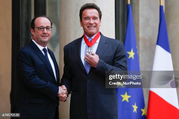 French President Francois Hollande shakes hands with US actor and former governor of California Arnold Schwarzenegger after he was awarded France's...