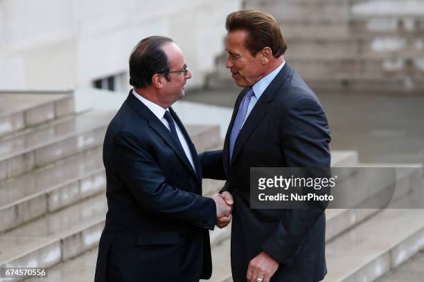 French president Francois Hollande shakes hands with actor and former governor of California Arnold Schwarzenegger prior to a meeting at the Elysee...