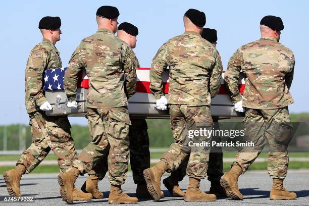Army soldiers carry the flag-draped transfer case containing the remains of U.S. Army Ranger Sgt. Cameron H. Thomas during a dignified transfer at...