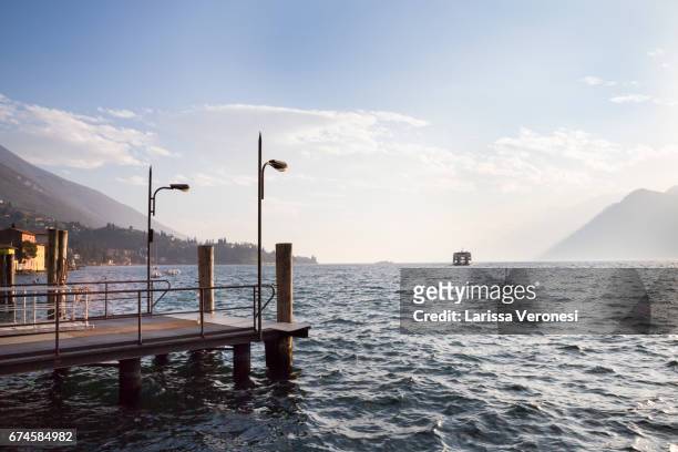 italy, lake garda, malcesine, harbor with ferry boat at sunset - larissa veronesi bildbanksfoton och bilder