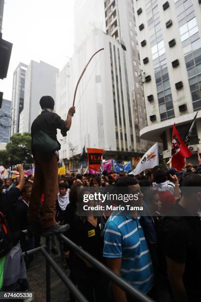 Protestor stands holding a bow at demonstrations during a nationwide general strike on April 28, 2017 in Rio de Janeiro, Brazil. The general strike...