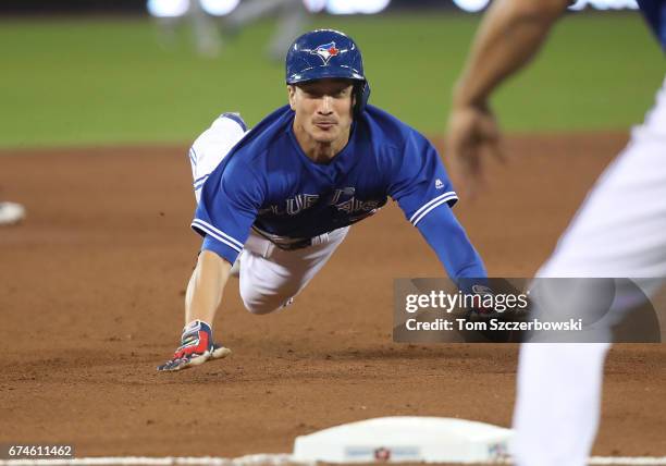 Darwin Barney of the Toronto Blue Jays advances safely from first base to third base on a single by Jose Bautista in the fifth inning during MLB game...