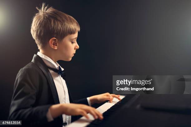 little boy virtuoso performing piano concerto - one boy only stock pictures, royalty-free photos & images