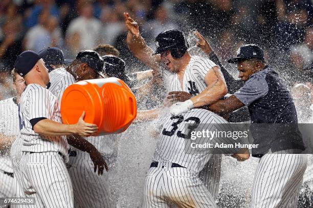 Matt Holliday of the New York Yankees is congratulated by teammates after hitting the game winning 3-run home run against the Baltimore Orioles...