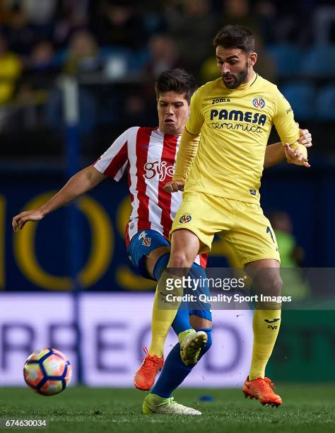 Adrian Lopez of Villarreal competes for the ball with Jorge Mere of Real Sporting de Gijon during the La Liga match between Villarreal CF and Real...