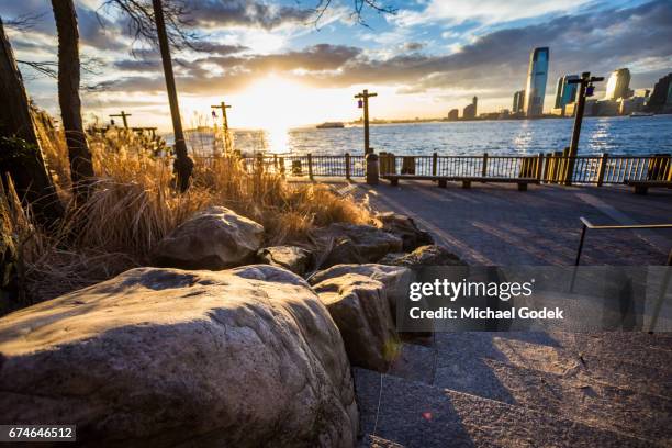 battery park hudson river water front during dramatic cloudscape sunset new york city - battery park stock pictures, royalty-free photos & images